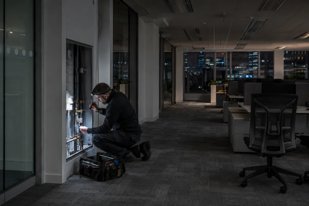 Engineer carrying out maintenance work in a London office after hours